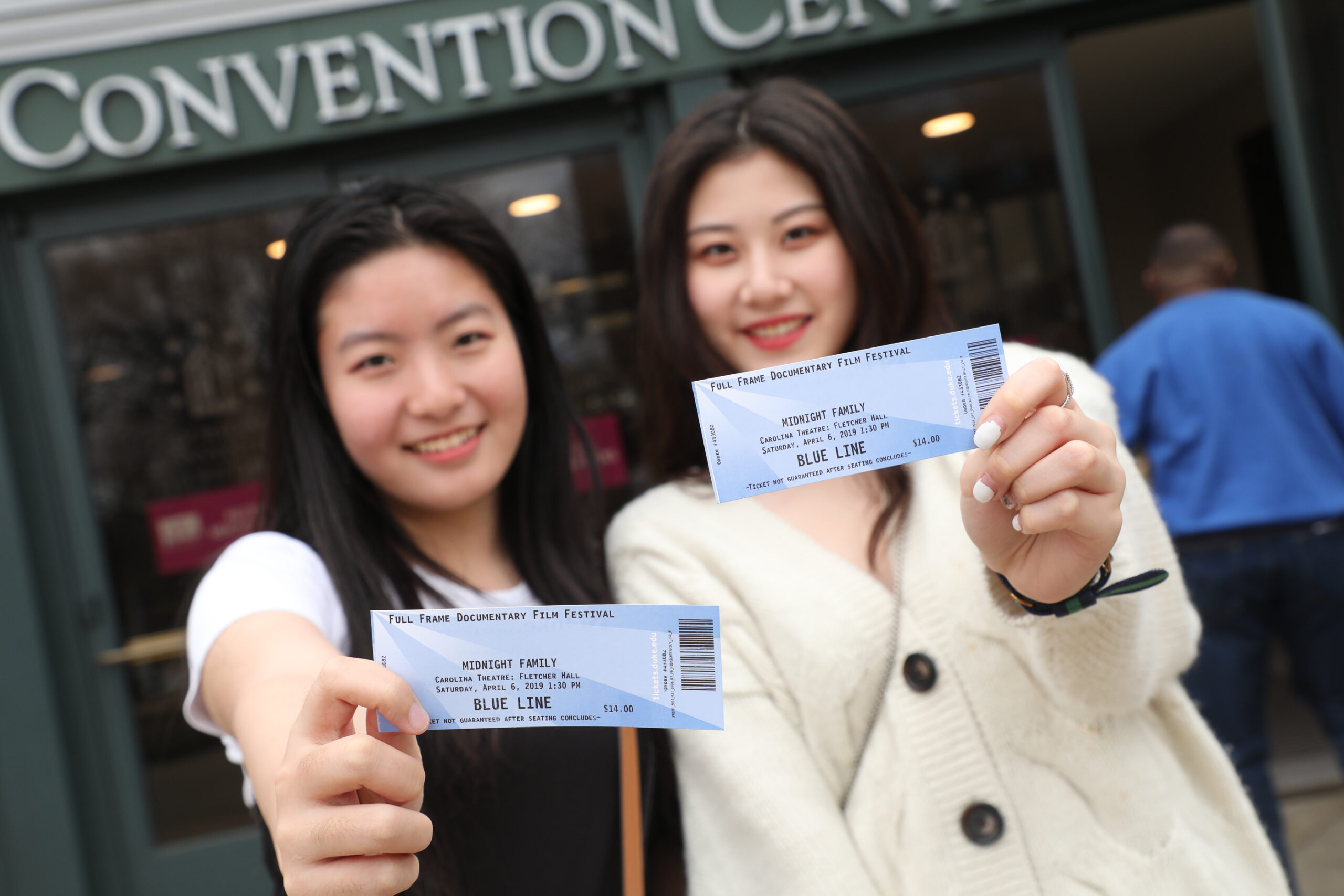 Two women holding Full Frame tickets